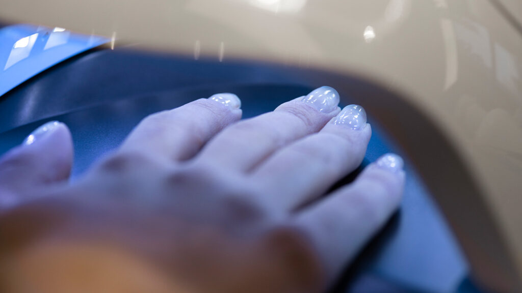 Nail designer profissional realizando a etapa de preparação e aplicação da esmaltação em gel em Vinhedo no salão Lumière Concept.